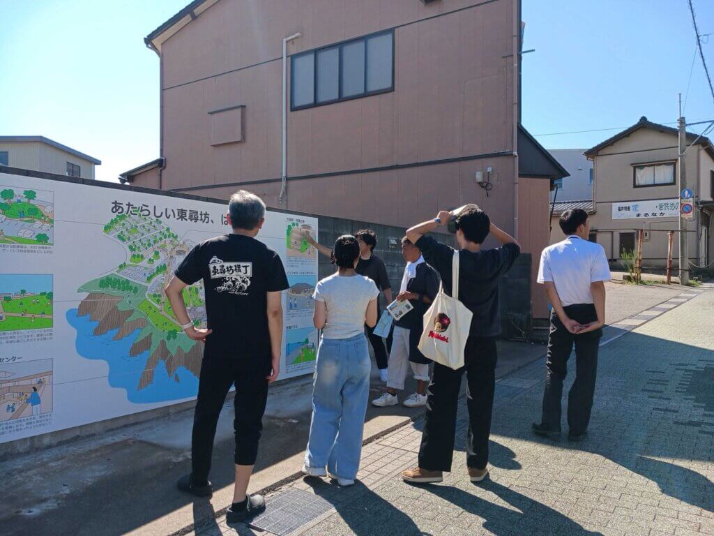 東尋坊の再整備計画のパネルを見ながらまちを歩く一行